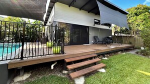 A modern house with a wooden deck, a pool, and a covered patio area. - Garden Retreat with Pool - fully detached Studio (Freshwater)