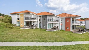 A modern multi-story residential building with balconies and a paved driveway. - Gudhjem Søpark Lejl. 42 (Gudhjem)