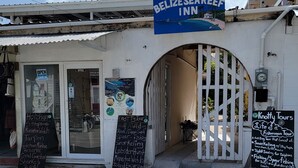 A Belize Sea Reef Inn with a signboard advertising activities like snorkeling and fishing. - Belize Sea Reef Inn (Caye Caulker)