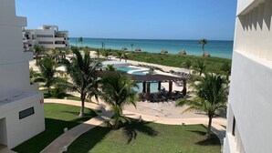 Un resort con area piscina, palme e vista sull'oceano.