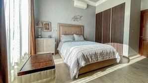 A bedroom with a bed, dresser, and wardrobe.