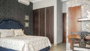 A bedroom with a bed, a wardrobe, a chair with a pineapple decoration, and a shelf with a bust.