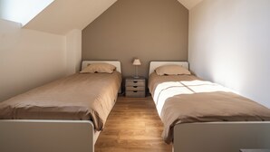 A bedroom with two beds, a nightstand, and a lamp. - Parenthèse Tourangelle - Families & Business (Tours)