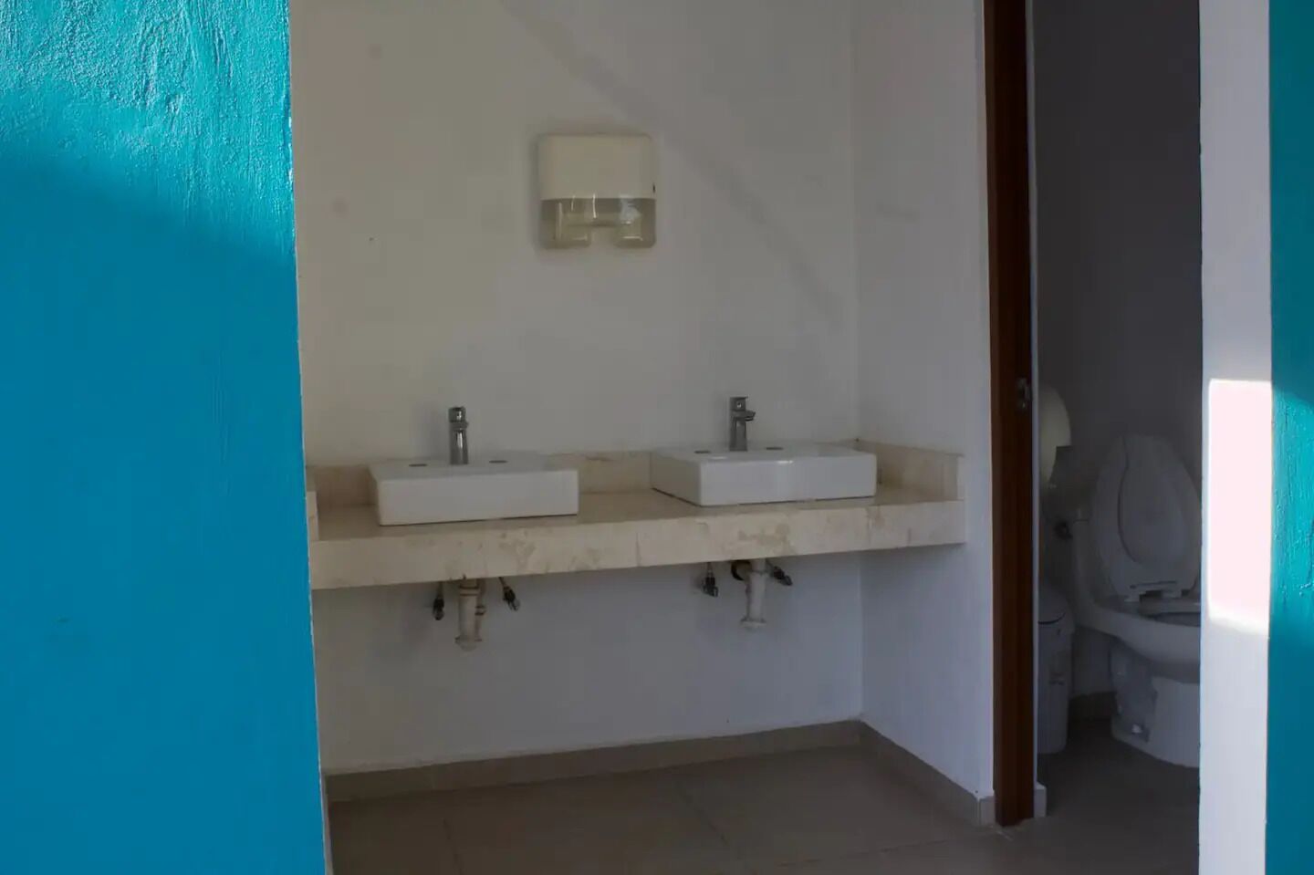 Een badkamer met twee wastafels, een spiegel en een lamp.