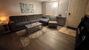 A living room with a grey sofa, a patterned armchair, a coffee table, and a decorative wall piece. - ~A Home Away From Home~Sleeps 8~

 (Columbia)