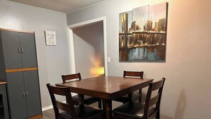 A dining area with a wooden table and four chairs, a cabinet, and a painting on the wall. - ~A Home Away From Home~Sleeps 8~

 (Columbia)