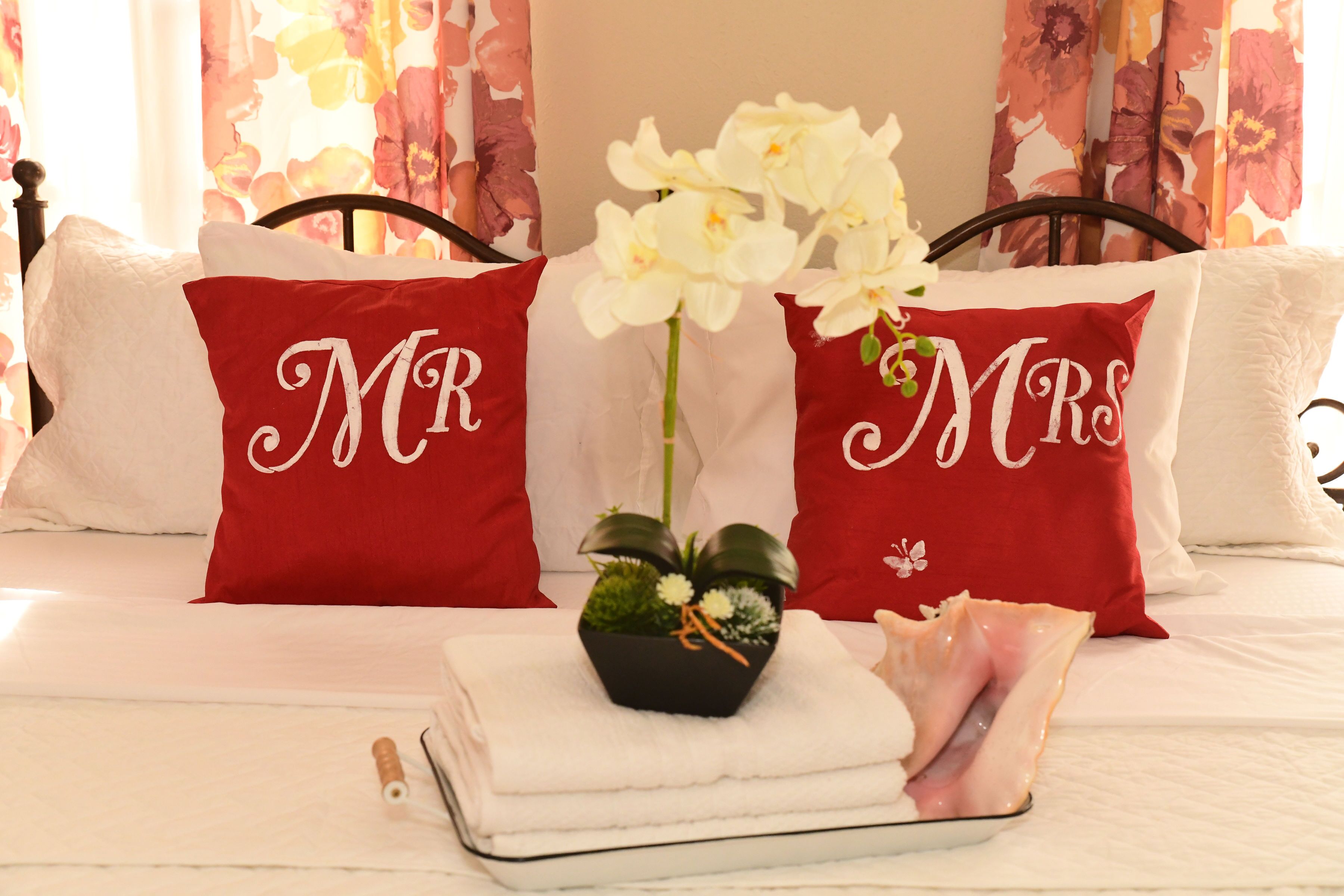 Un llit amb almoinos etiquetades "MR" i "MRS" i una petita planta al llit.