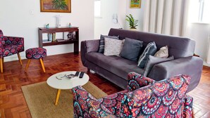 A living room with a sofa, patterned armchairs, a coffee table, and a painting on the wall. - Copacabana Comfort Home (Rio de Janeiro)