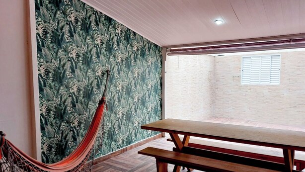 A room with a hammock, a wooden bench, and a large window. - Copacabana Comfort Home (Rio de Janeiro)