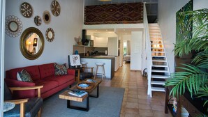 A spacious living area with a red sofa, coffee table, and a staircase leading to an upper level. - Orient Parc - the best location (Saint martin)
