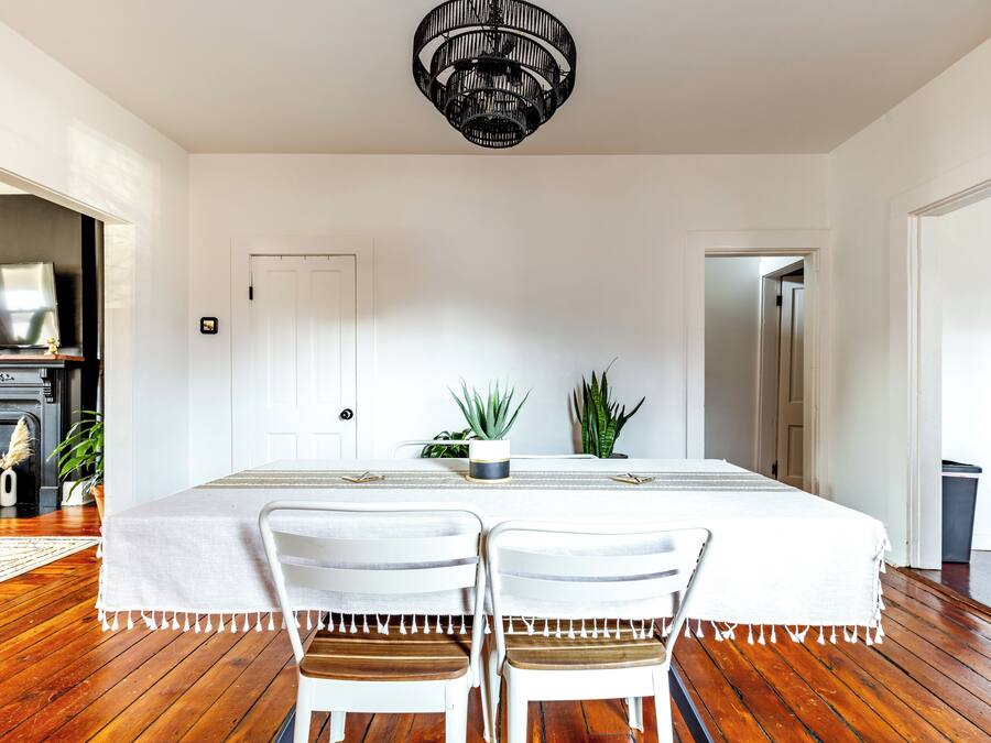 Un comedor con mesa, sillas, candelabro y chimenea.