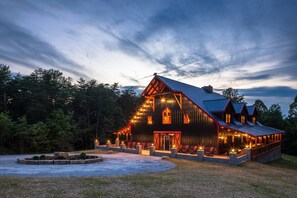 Una casa grande de madera oscura con varias ventanas y un porche.