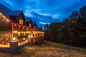 Un grand bâtiment moderne doté d’un espace extérieur abrité comprenant plusieurs coins salon et un barbecue.