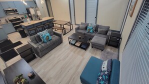A modern living space with a kitchen, dining area, and seating area. - Newly built, Pool, Pier, Elec. Golf Cart, Elevator, Sleep 10, 2 min walk to surf (Navarre)