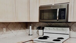 Une cuisine équipée d’un four à micro-ondes, d’une cuisinière et d’un évier intégrés.