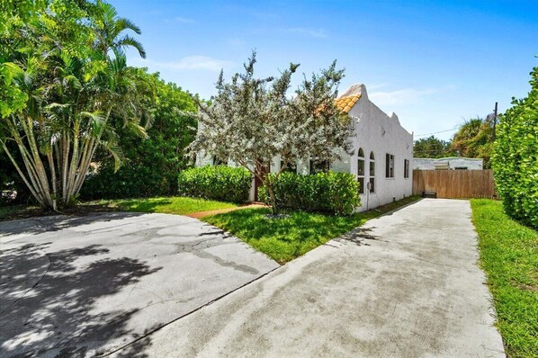 Stunning single-story home with a unique architectural style, set amidst a lush green neighborhood.