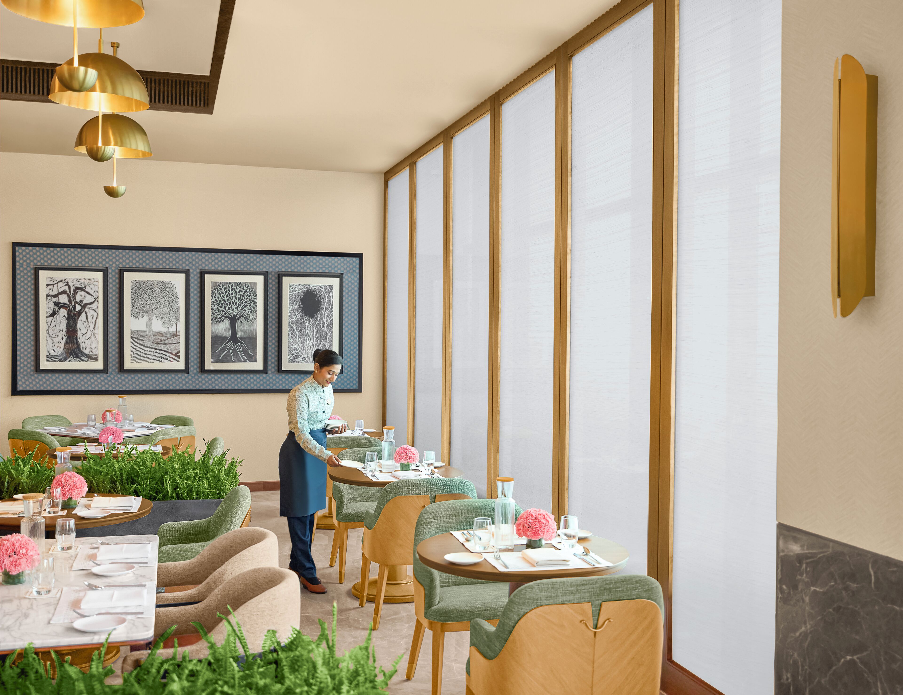 A restaurant with a modern interior, featuring a waiter attending to a table.