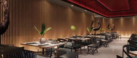 A modern restaurant with wooden panel walls, green plants, and a red ceiling. Tables and chairs are arranged for dining.