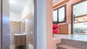 A modern bathroom with a wooden vanity, a mirror, and a shower area. - Pintada by Interhome (Villasimius)