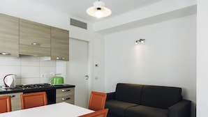 Een moderne keuken met een eethoek, een bank en een tafel.