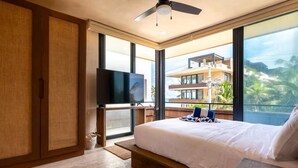 A hotel room with a bed, a TV, a balcony with a view, and a ceiling fan. - BT Homes - Tankah Bay (Tulum)