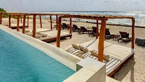 A poolside area with lounge chairs and a pergola overlooking the beach. - BT Homes - Tankah Bay (Tulum)