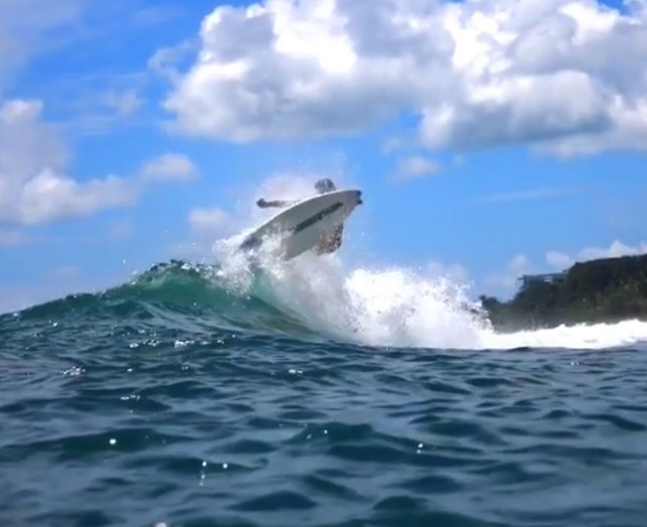 A boat riding a wave in the ocean.