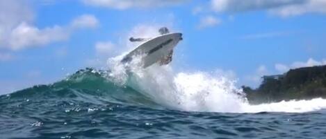 A boat riding a wave in the ocean.