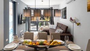 Een eethoek met een tafel gedekt voor vier personen, een fruitschaal en uitzicht op de omgeving.