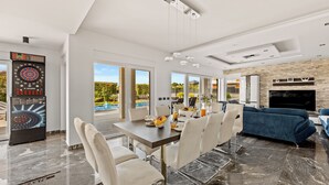 A modern living room with a dining area, a dartboard, and a TV. - Villa Mersi (Istria - Pula) (Pula)