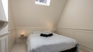 A bedroom with a bed, bedside table, lamp, and a small window. - Arras quartier préfecture : 2 pièces calme (Arras)