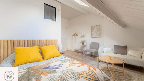 A bedroom with a bed, a small table, a sofa, and a chair. - Les combles d'Eugene, proche Bollaert, 2pers (Lens)