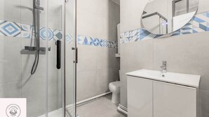 A modern bathroom with a glass-enclosed shower, a toilet, and a sink with a mirror above it. - Les combles d'Eugene, proche Bollaert, 2pers (Lens)