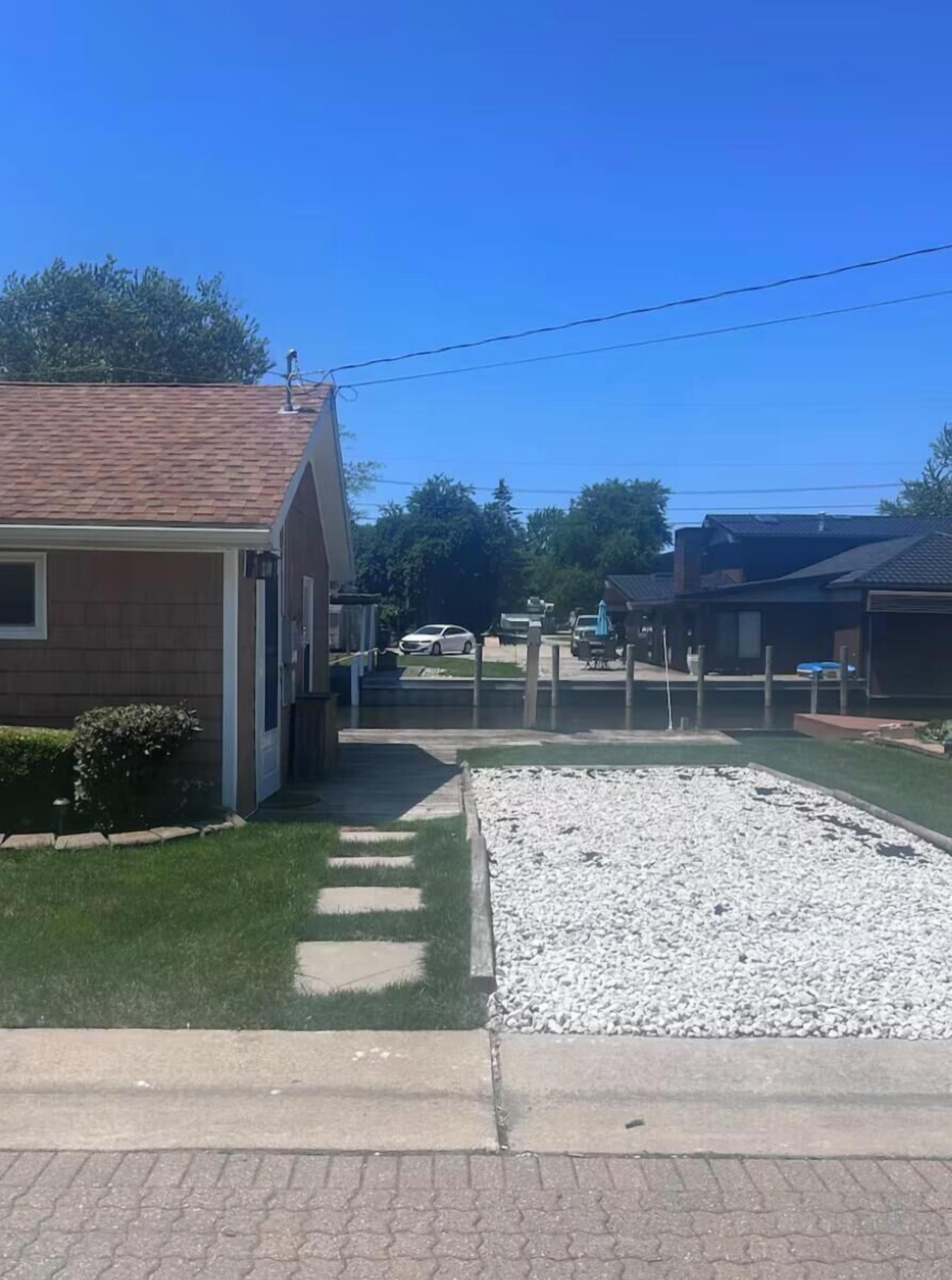 A residential area with houses, a driveway, and a gravel area.