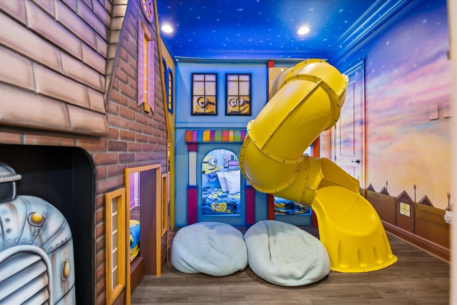 A play area with a slide, bean bags, and a Minion-themed window.