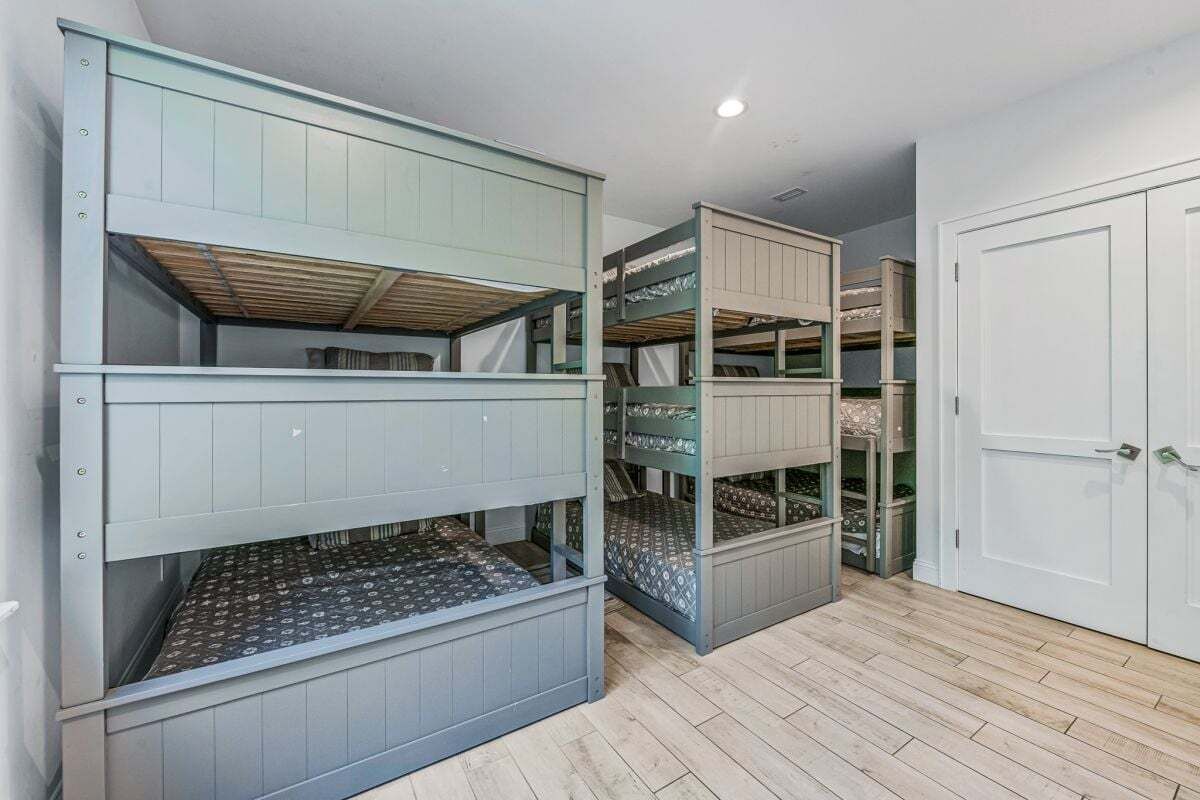 Une chambre avec des lits superposés, une armoire et une porte.
