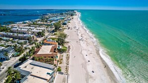 An aerial view of a coastal area with a beach, buildings, and a pier. - Anna Maria Grand: Gulf Front! On the Beach! Sleeps 22 by Anna Maria Life Vacation Rentals (Bradenton Beach)