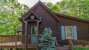 A log cabin with a balcony, a door, and a small staircase. - Annie's Cabin | Pet Friendly | Mountain View | Hot Tub | Fire Pit (Fairview)