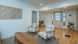 Un salon spacieux avec une table basse en bois, deux fauteuils et un tapis.