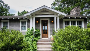 Ein Haus mit einer Veranda, Steinstufen und einem Steinsschornstein.