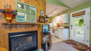 A cozy living room with a fireplace, a television, and a bookshelf.