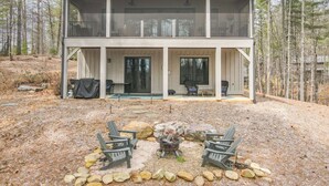 A two-story house with a covered patio area featuring outdoor seating and a fire pit. - Birdsong | Fire Pit & Easy Access to Lake James! (Nebo)