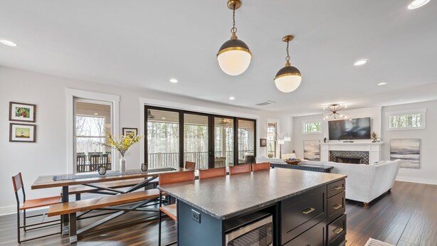 A spacious kitchen with a large island, dark wood flooring, and pendant lighting. - Birdsong | Fire Pit & Easy Access to Lake James! (Nebo)