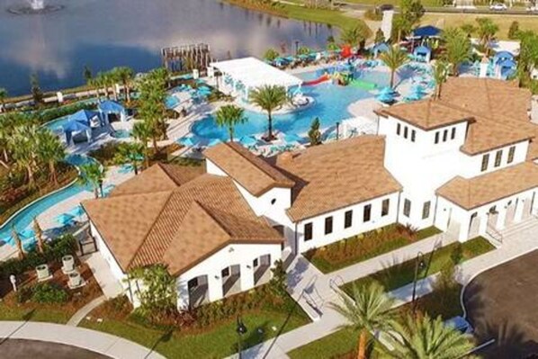 Et resort med swimmingpool, palmer og en bygning med tegltag.