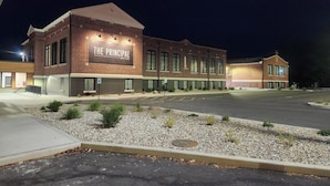 A hotel named "The Principal Hotel" with a brick facade, multiple windows, and a parking lot in front. - The Principal Hotel (Columbia)