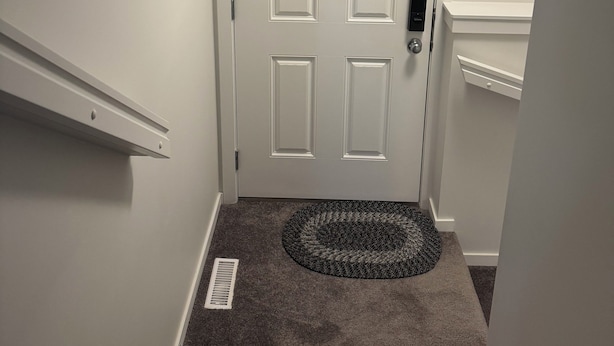 A white door with a small window above it, a doormat, and a carpeted staircase. - Entire Guest Suite/Separate Entrance/Free Parking in Winnipeg (Winnipeg)