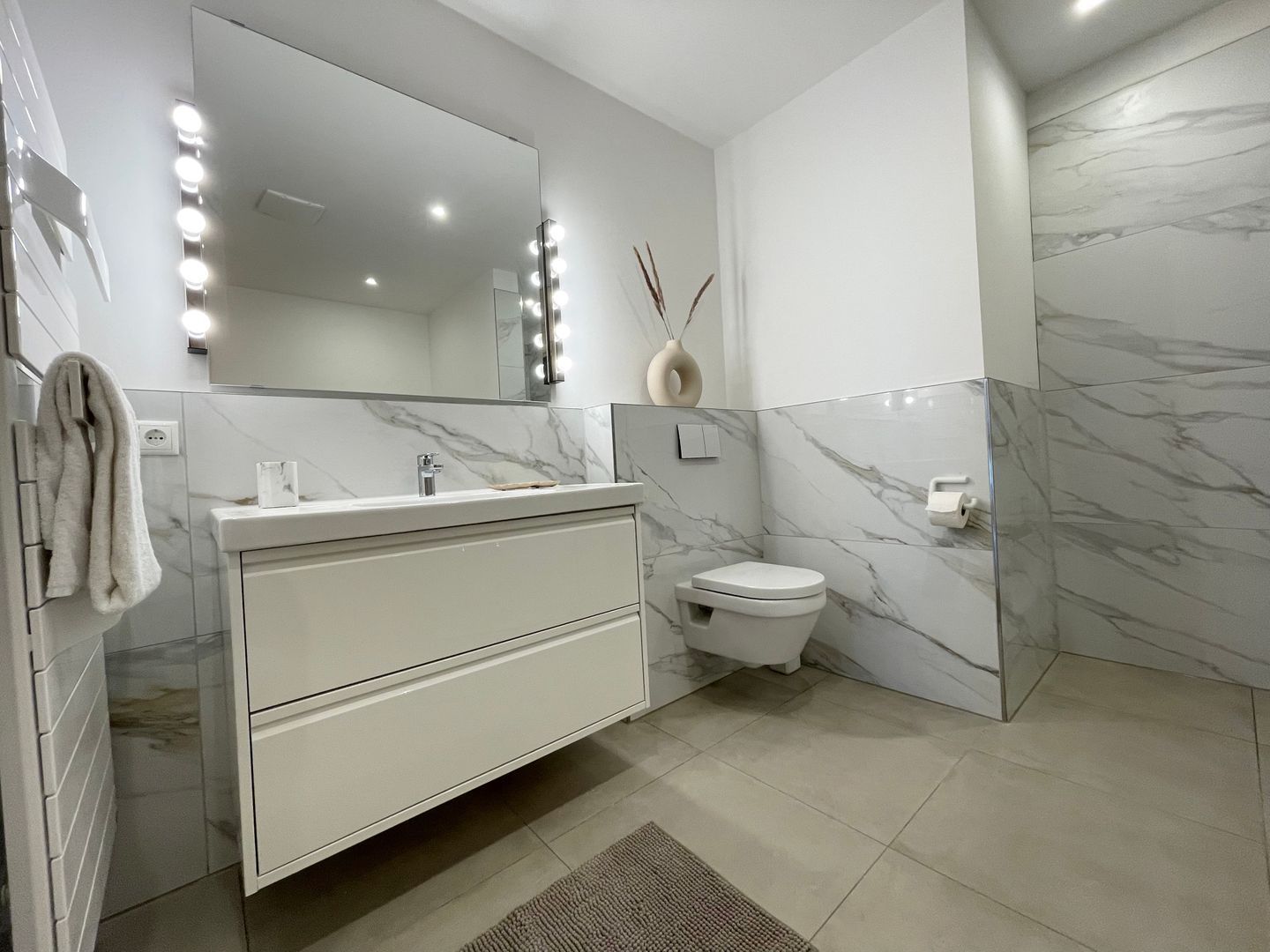Une salle de bain moderne avec un meuble-lavabo, un miroir et des toilettes.