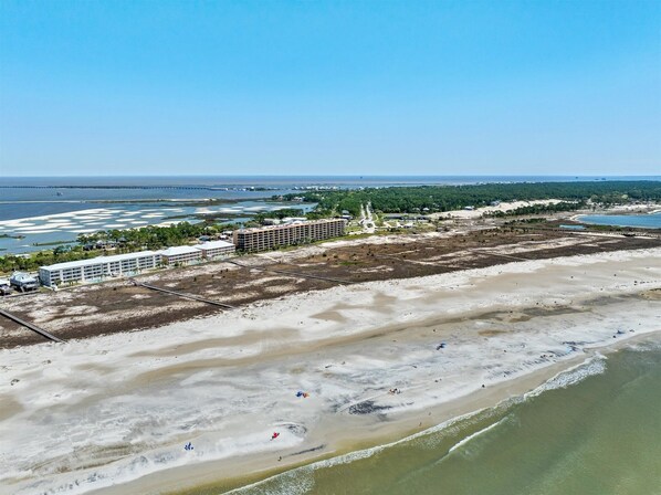 Un hôtel situé sur la côte, composé de plusieurs bâtiments, avec une plage et un port de plaisance.