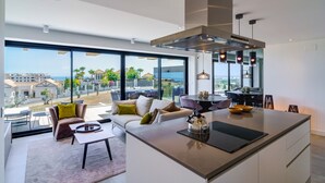 A modern kitchen with a large island, a dining area with a table and chairs, and a seating area with a sofa and armchairs. - Apartment 'Oasis 325' with Sea View, Wi-Fi and Air Conditioning (Estepona)