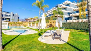 A modern hotel with a pool area, outdoor seating, and a view of the surrounding landscape. - Apartment 'Oasis 325' with Sea View, Wi-Fi and Air Conditioning (Estepona)